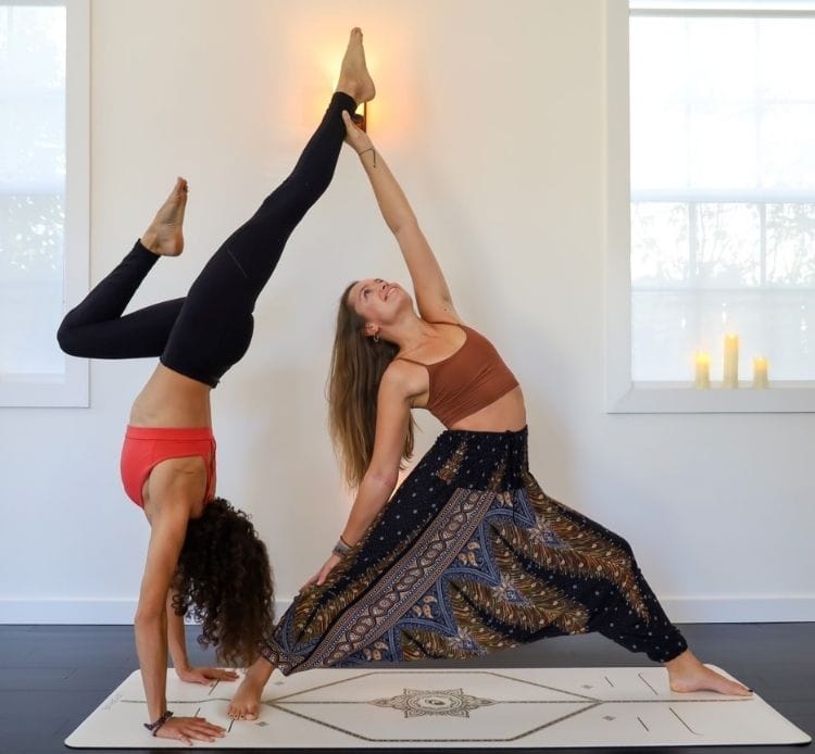 two yoga instructors doing yoga in delray beach yoga studio